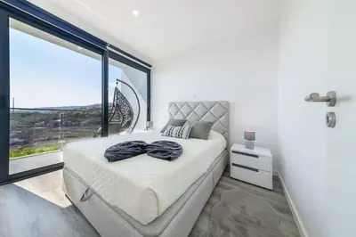 a bedroom with a bed with a large window at Ocean Valley by Mth in Ribeira Brava
