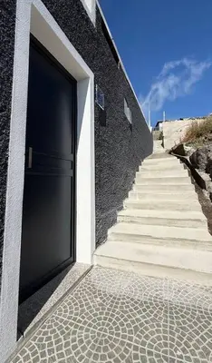a large door on a building with stairs next to it at Ocean Valley by Mth in Ribeira Brava