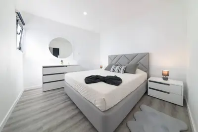 a white bedroom with a large bed and a mirror at Ocean Valley by Mth in Ribeira Brava