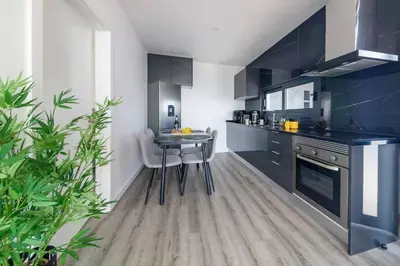 a kitchen with black cabinets and a table and chairs at Ocean Valley by Mth in Ribeira Brava