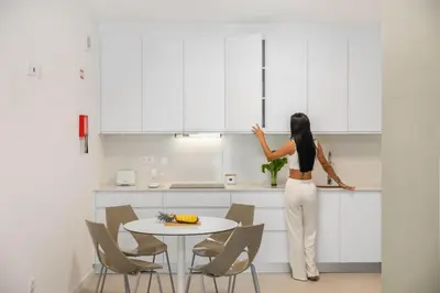 a woman standing in a kitchen looking at cabinets at Atlantic Pebble Villa in Ribeira Brava