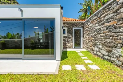 an image of a stone house with a sliding glass door at Atlantic Pebble Villa in Ribeira Brava