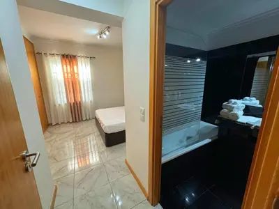 a bathroom with a walk in shower next to a bedroom at Funchal Cozy Private Room, Ensuite Bathroom, WiFi and Great Location in Funchal