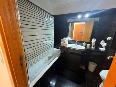 a black bathroom with a sink and a mirror at Funchal Cozy Private Room, Ensuite Bathroom, WiFi and Great Location in Funchal