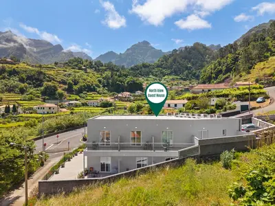 a building with a green sign on top of it at North View Guesthouse in Senhora do Rosário