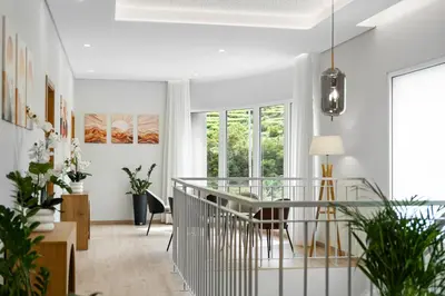 a dining room with white walls and a glass table at North View Guesthouse in Senhora do Rosário