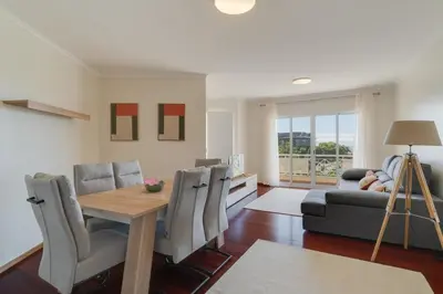 a living room with a table and chairs and a couch at Sao Joao- 3 Bedroom apartment in Funchal