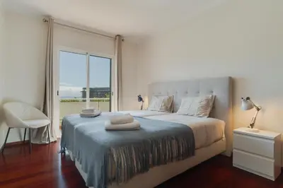 a bedroom with a large bed with a large window at Sao Joao- 3 Bedroom apartment in Funchal
