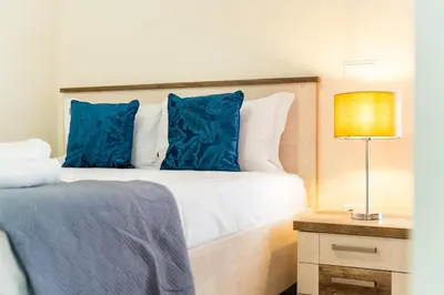 a bedroom with a bed with blue pillows and a lamp at GuestReady - Typical experience in Funchal in Funchal