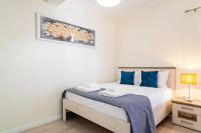 a bedroom with a bed with blue pillows at GuestReady - Typical experience in Funchal in Funchal