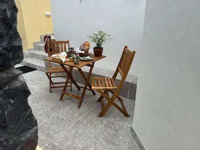 a table with two chairs and a table with a plant at Refúgio do Nevoeiro Apart T1 in Porto Moniz