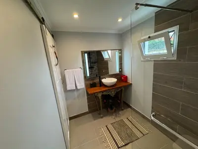 a bathroom with a sink and a shower at Refúgio do Nevoeiro Apart T1 in Porto Moniz