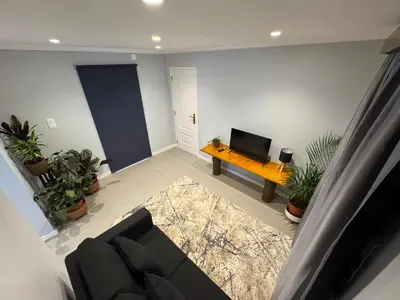 a living room with a couch and a tv at Refúgio do Nevoeiro Apart T1 in Porto Moniz