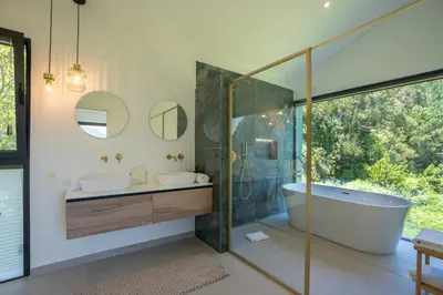 a bathroom with a tub and a sink and a mirror at Panorama House by LovelyStay in São Vicente