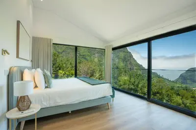 a bedroom with a bed with a view of the ocean at Panorama House by LovelyStay in São Vicente