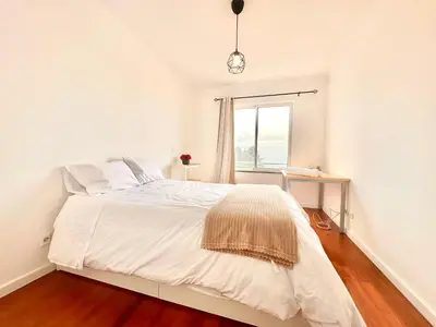 a white bedroom with a bed and a window at Edna 1 in Funchal