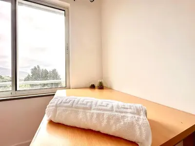 a bedroom with a wooden table and a window at Edna 1 in Funchal