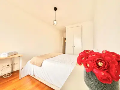 a bedroom with a bed and a vase with a red flower at Edna 1 in Funchal