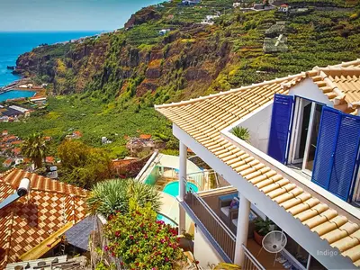a group of people sitting at a table on a balcony at Indigo Star House in Ribeira Brava