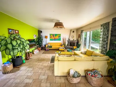 a living room with a yellow couch and green walls at Indigo Star House in Ribeira Brava