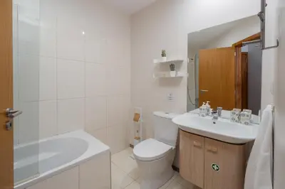 a white bathroom with a toilet and a sink at Alta Vista Caniço by An Island Apart in Santa Cruz