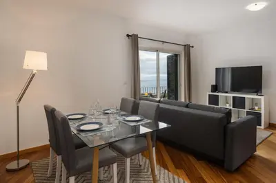 a living room with a table and a couch at Alta Vista Caniço by An Island Apart in Santa Cruz