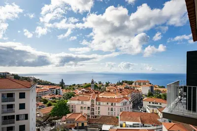 a cityscape of a city with buildings and the ocean at Alta Vista Caniço by An Island Apart in Santa Cruz