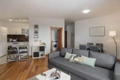 a living room with a gray couch and a kitchen at Alta Vista Caniço by An Island Apart in Santa Cruz