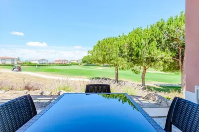 a dining table with a view of a golf course at Casa Maria at Boavista Resort Lagos in Atalaia