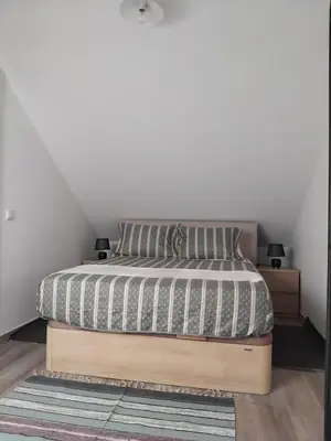 a bedroom with a bed with a white wall at MM House in Bicas