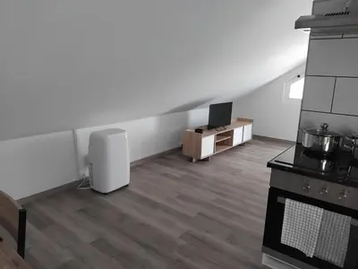 a room with a kitchen with a stove and a tv at MM House in Bicas