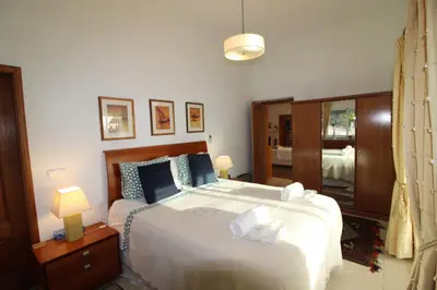 a bedroom with a large white bed and a mirror at Casa Tenente Camilo in Lagos