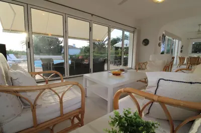 a living room with chairs and tables and windows at Casa Tenente Camilo in Lagos