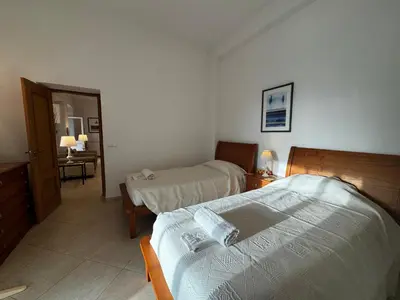 a hotel room with two beds and a desk at Casa Tenente Camilo in Lagos