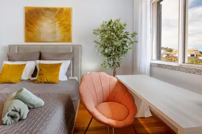 a bedroom with a bed with a desk and a chair at Ti Clara View Apartment in Caniço