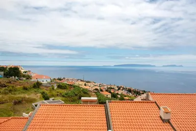 a view of a town with orange roofs and the ocean at Ti Clara View Apartment in Caniço