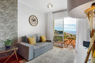 a living room with a couch and a balcony at Ti Clara View Apartment in Caniço