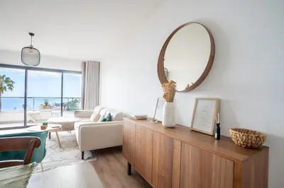 a living room with a large mirror on the wall at Hygge Madeira by LovelyStay in Caniço