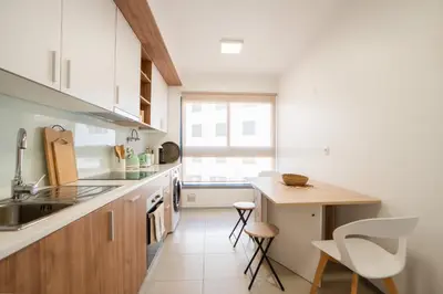 a kitchen with a counter and a table and chairs at Hygge Madeira by LovelyStay in Caniço