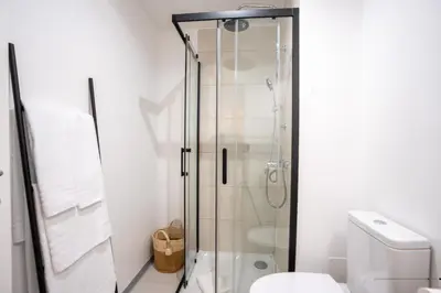 a glass shower in a bathroom with a toilet at Hygge Madeira by LovelyStay in Caniço