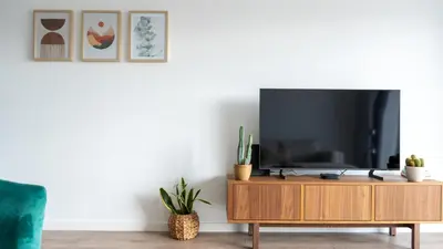 a living room with a tv on a wooden cabinet at Hygge Madeira by LovelyStay in Caniço