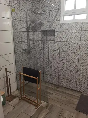 a shower with a chair in a bathroom at Honey Factory House in Santa Cruz