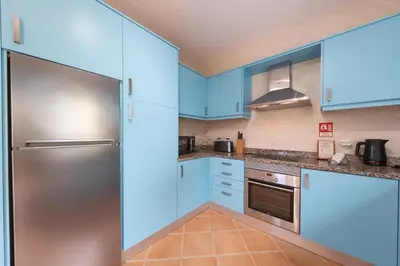 a kitchen with blue cabinets and a stainless steel refrigerator at Villa Oxalis by Destination Algarve in Atalaia