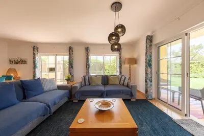 a living room with blue couches and a table at Villa Oxalis by Destination Algarve in Atalaia