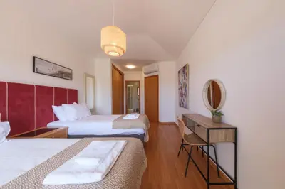 a hotel room with two beds and a desk at Villa Oxalis by Destination Algarve in Atalaia