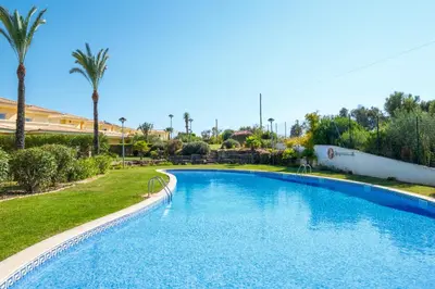 a swimming pool in a resort with palm trees at Villa Oxalis by Destination Algarve in Atalaia