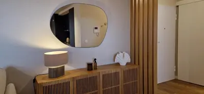 a mirror on a wall above a table with a lamp at Shell Living - KOS in Funchal