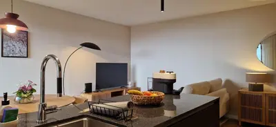 a living room with a kitchen and a living room with a television at Shell Living - KOS in Funchal