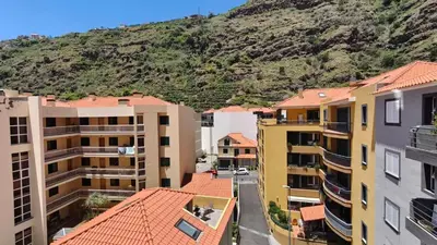 an aerial view of buildings with a mountain in the background at Apartamento Luar in Ribeira Brava
