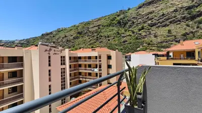 a view from the balcony of a building with a mountain in the background at Apartamento Luar in Ribeira Brava